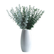 White vase with greenery on a white background