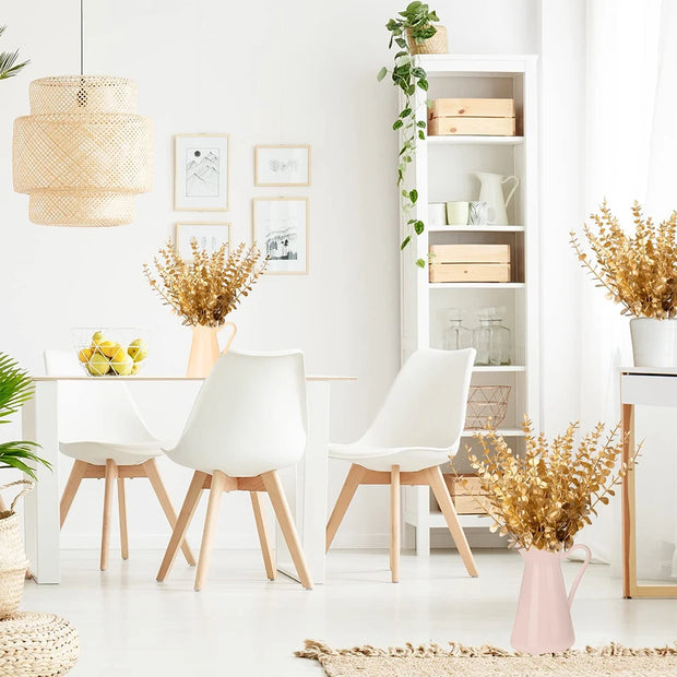 Modern dining room with white chairs, a table, and decorative elements.