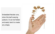 Hand holding a decorative gold leaf branch with text on a white background