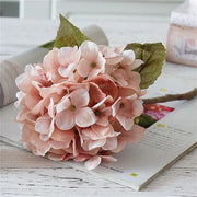 Pink artificial flower arrangement on an open magazine