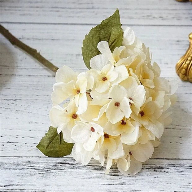 Bouquet of white flowers with green leaves on a wooden surface