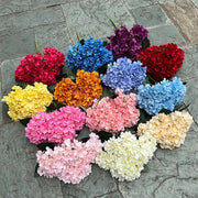 Assorted colored flowers arranged in a circular pattern on a stone surface.