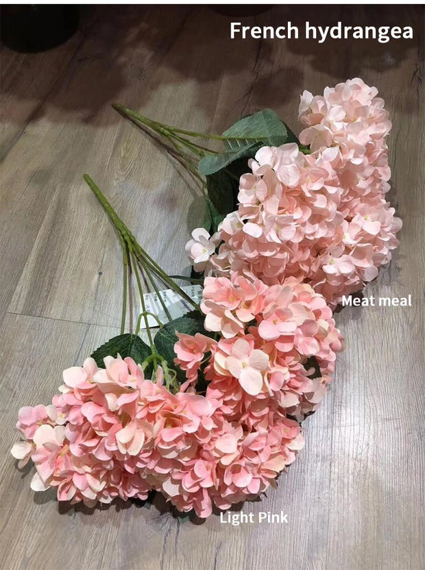 Bouquet of pink French hydrangea flowers on a wooden surface with labels for 'Light Pink' and 'Meat meal'.