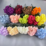 Assorted colorful flowers arranged in a circular pattern on a gray background