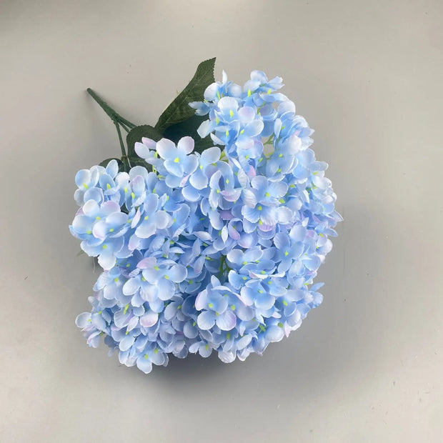 Bouquet of light blue artificial flowers on a plain background