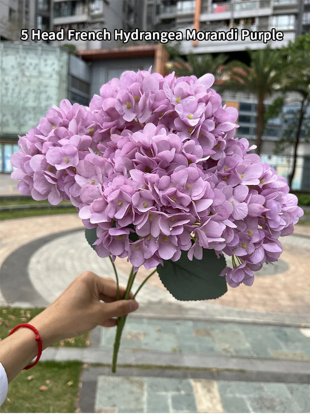 Bouquet of French Hydrangea Morandi Purple held by a person outdoors.