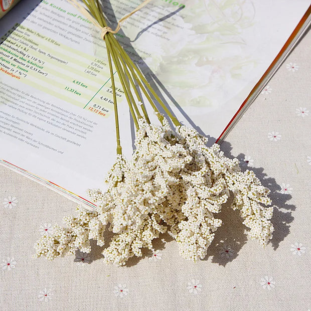Bouquet of white flowers on an open book with a floral patterned cover.