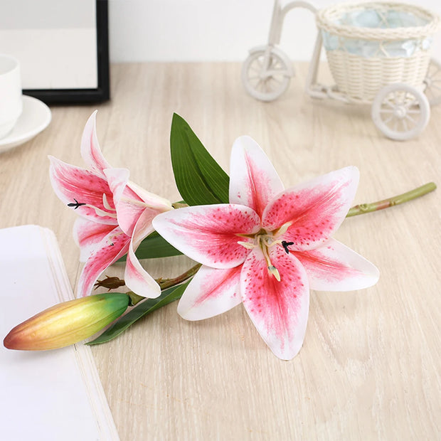 Pink and white lilies on a wooden surface with a blurred background
