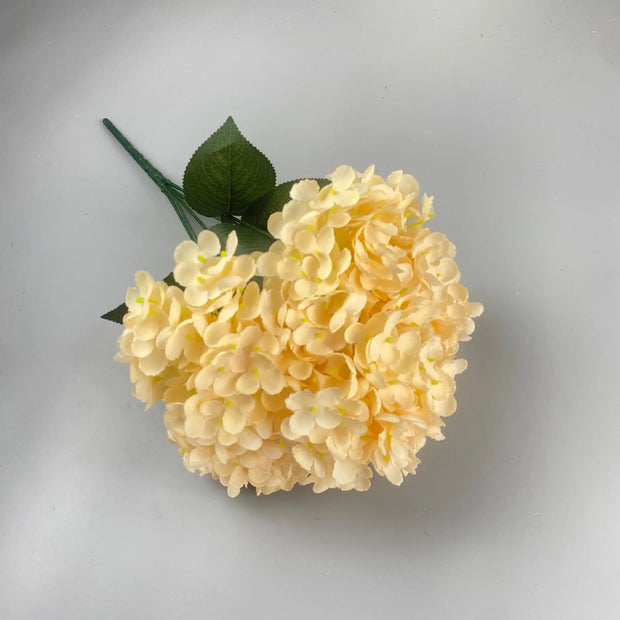 Yellow artificial flower arrangement on a light gray background