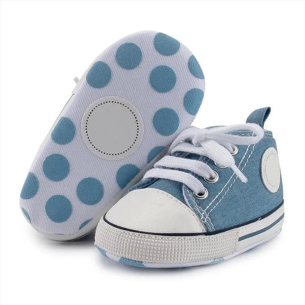 Blue baby shoes with white polka dots on a white background