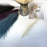 Dried flowers and a vase on a white surface with a card labeled 'Flowers'.