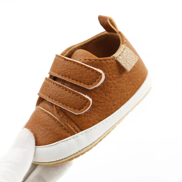 Brown baby shoe with velcro straps on a white background