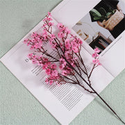 Pink artificial flower branch on an open magazine