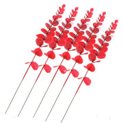 Red artificial leaves on sticks against a white background