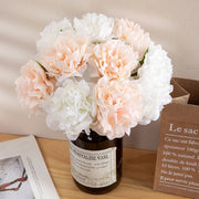 Bouquet of pink and white flowers in a minimalistic vase on a wooden surface.