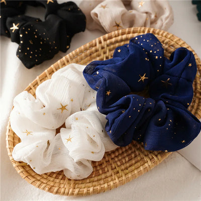 Navy and white scrunchies with star patterns on a woven tray.