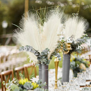 Decorative floral arrangement with pampas grass and eucalyptus on a table setting.