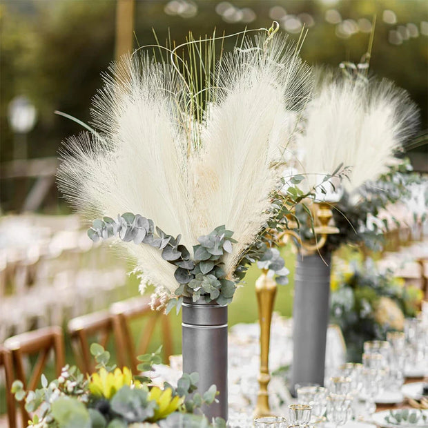 Decorative floral arrangement with pampas grass and eucalyptus on a table setting.