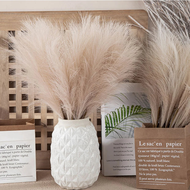 White textured vase with dried pampas grass against a neutral background