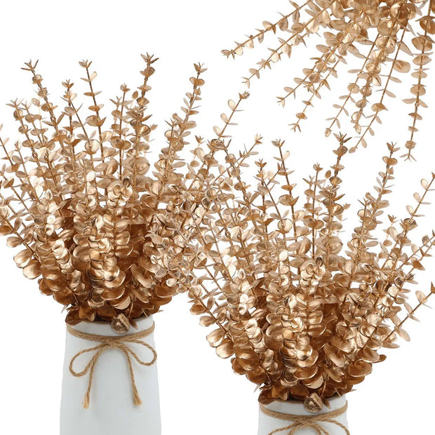 Gold leafed branches in white vases on a white background
