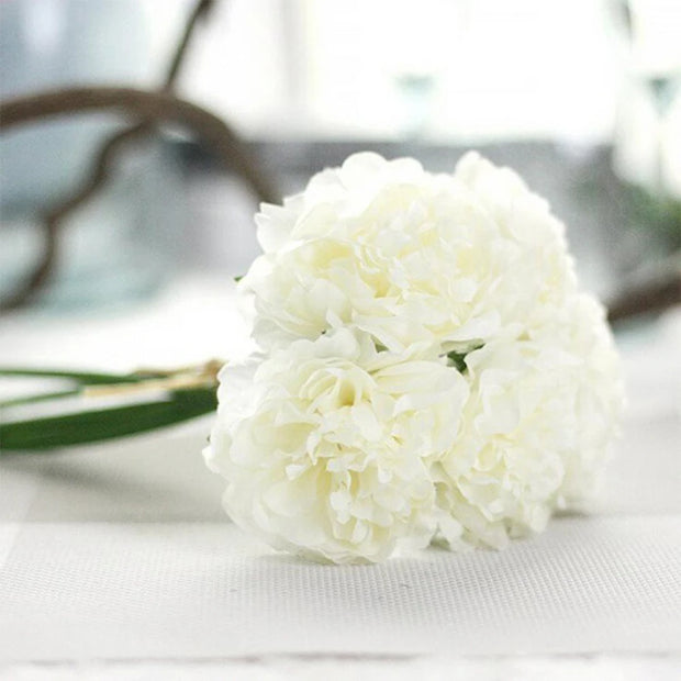 Bouquet of white flowers on a light surface with blurred background