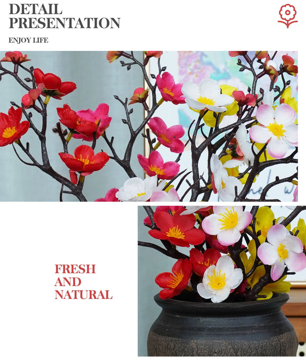Artificial flower arrangement with red, pink, and white flowers in a black pot on a light background.