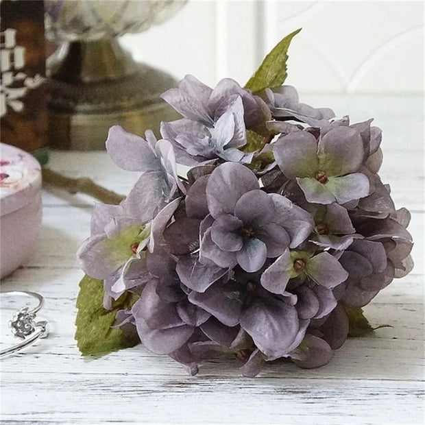 Purple flower headband on a wooden surface with a blurred background
