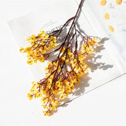Yellow dried flowers on a white surface with a polka dot pattern