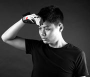 Person wearing a black t-shirt with a dark background