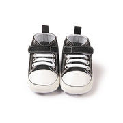 Pair of black high-top sneakers with white soles on a white background