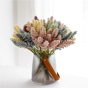 Bouquet of dried flowers in a textured vase with a brown handle on a white background