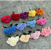 Assorted colorful artificial flowers arranged on a stone surface