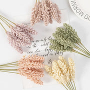 Bouquets of dried flowers in pink, green, and yellow on a white surface with cursive text.