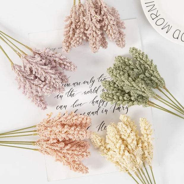 Bouquets of dried flowers in pink, green, and yellow on a white surface with cursive text.