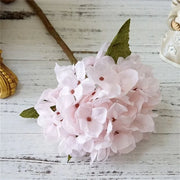 Pink artificial flowers on a wooden surface