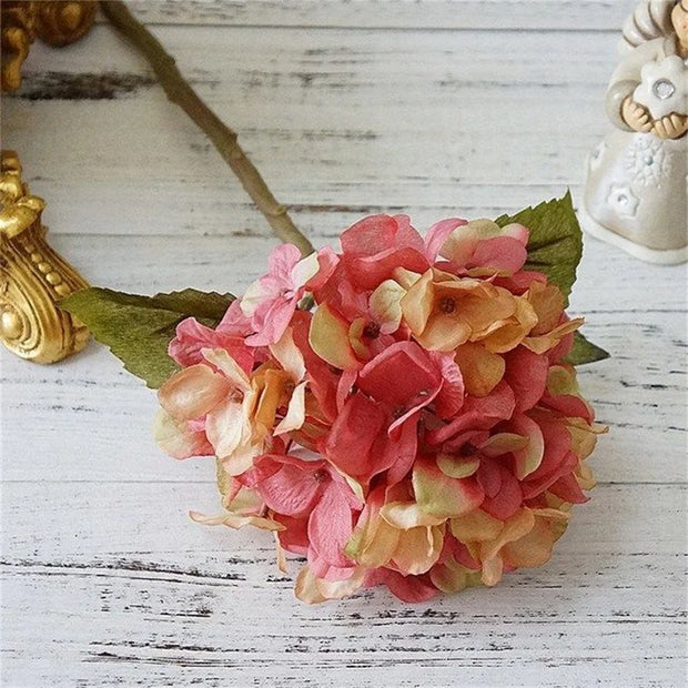 Floral headband with pink and orange flowers on a wooden surface