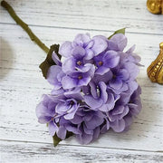 Purple flower arrangement on a wooden surface