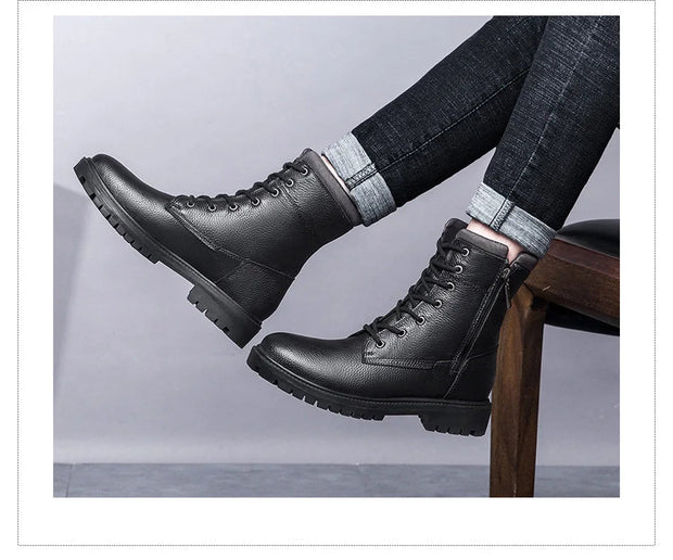 Black leather boots worn with jeans on a light gray background