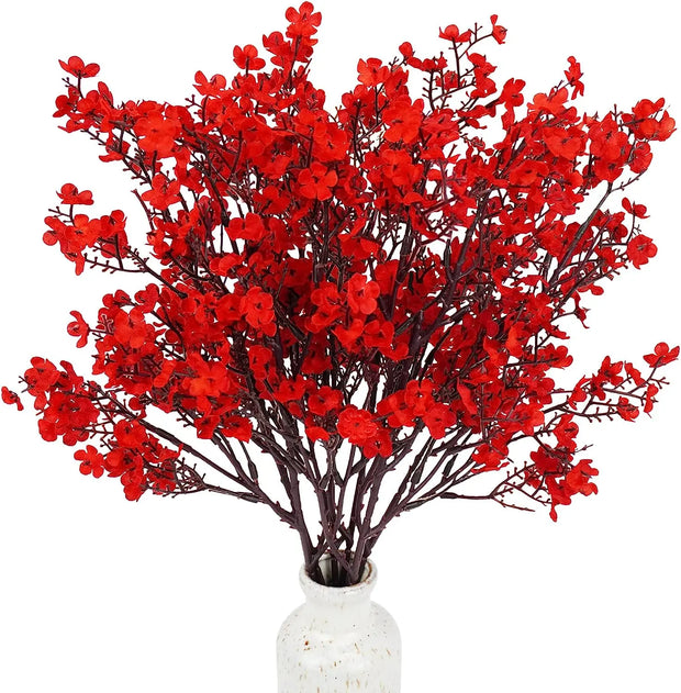 Bouquet of red artificial flowers in a white vase on a white background