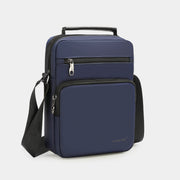 Navy blue crossbody bag with a visible brand logo on a light gray background