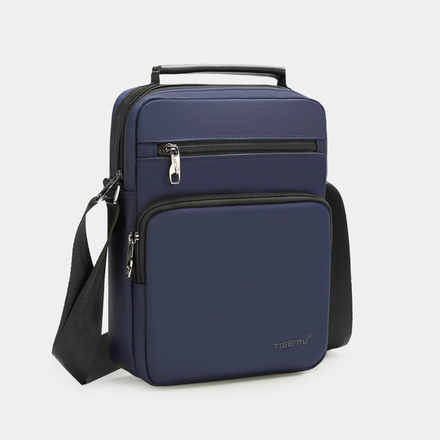 Navy blue crossbody bag with a visible brand logo on a light gray background