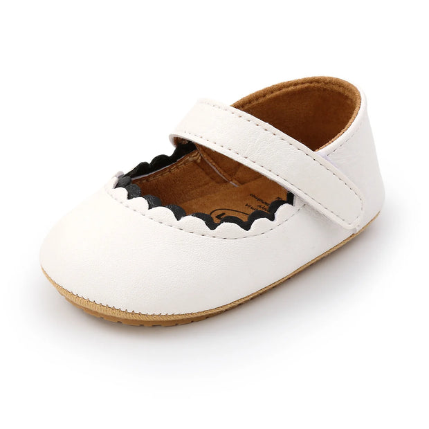 White baby shoe with brown sole on a white background