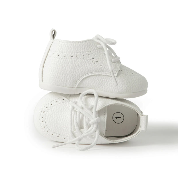 Pair of white baby shoes on a white background