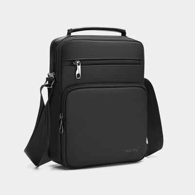 Black backpack with a shoulder strap on a light gray background