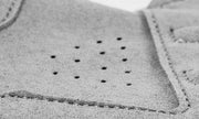 Close-up of a textured gray fabric with stitching details