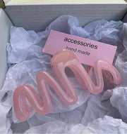 Pink hair accessories in a box with a 'handmade' label.