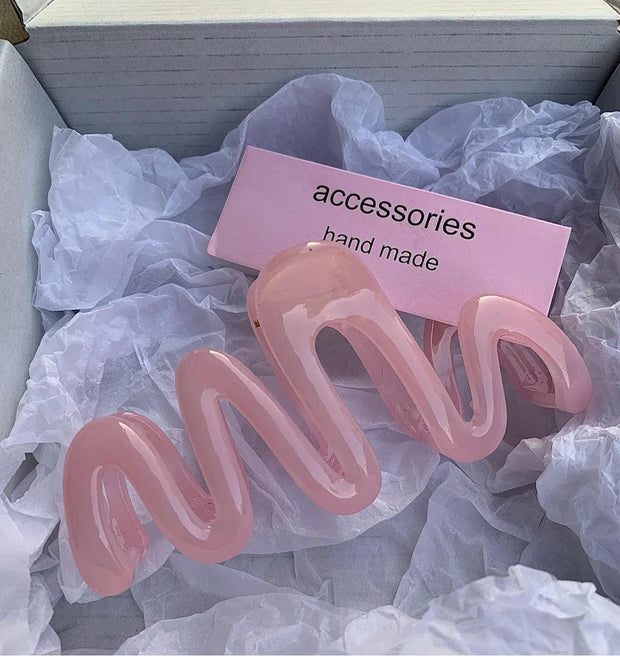 Pink hair accessories in a box with a 'handmade' label.