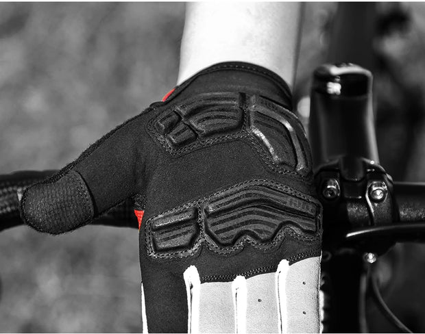 Close-up of a black and white glove on a bike handlebar with a blurred background