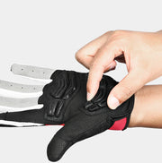 Person wearing a black and red glove with a finger being adjusted on a white background