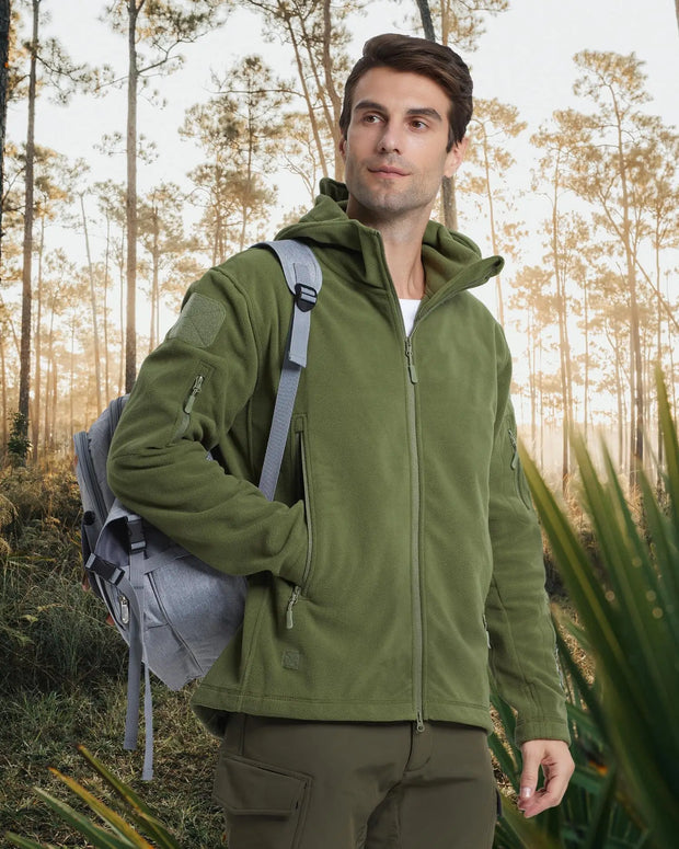 Man wearing a green jacket with a backpack in a forest setting